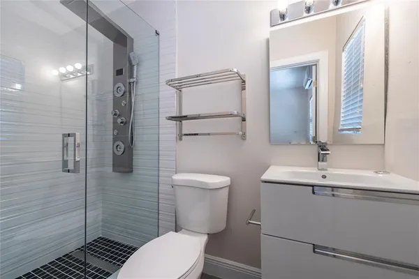 a bathroom with a sink a toilet and shower