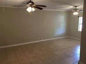 en empty room with ceiling fan and window