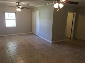 an empty room with chandelier fan