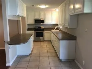 a kitchen with stainless steel appliances granite countertop a sink a stove and a refrigerator