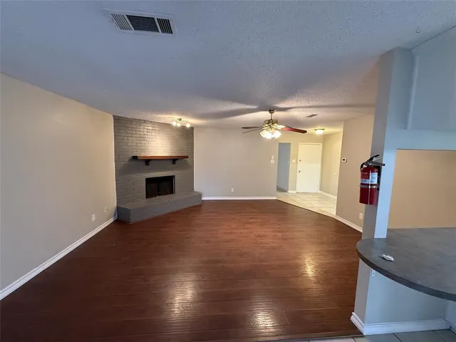 a view of an empty room with a fireplace and a window