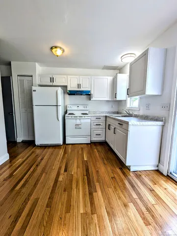 a kitchen with wooden floors and white appliances