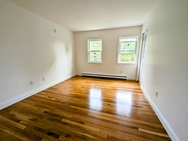 a view of empty room with wooden floor