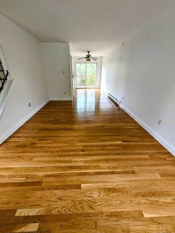 a view of empty room with wooden floor
