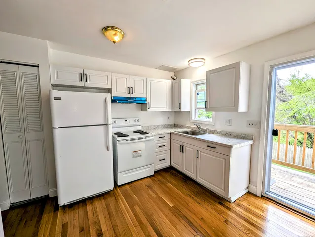 a kitchen with white cabinets and white appliances