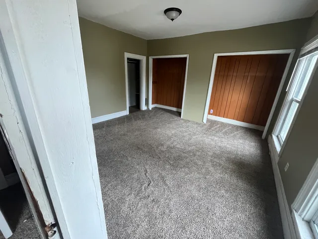 en empty room with windows and entrance