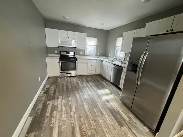a kitchen with granite countertop a refrigerator oven a sink and dishwasher
