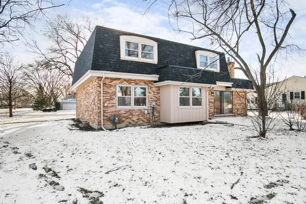 a front view of a house with a yard covered in snow
