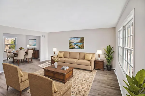 a living room with furniture potted plant next to a window and a potted plant