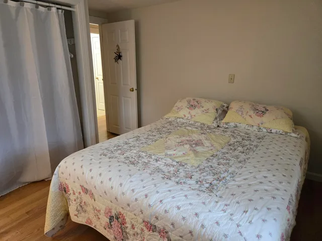 a bedroom with a bed and wooden floor