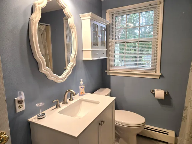 a bathroom with a sink toilet and a mirror