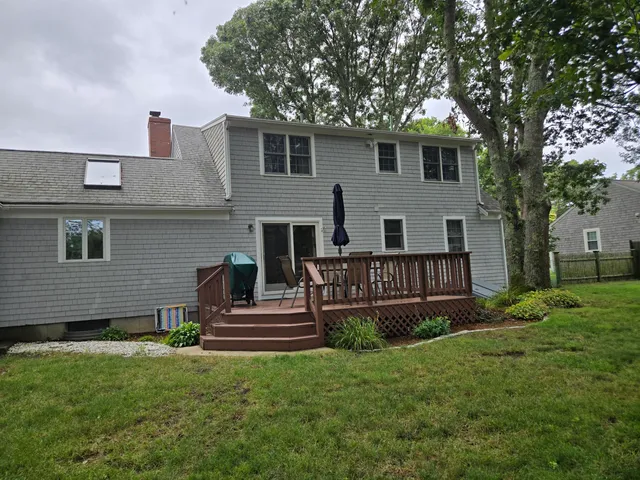 a view of backyard with wooden fence and large trees