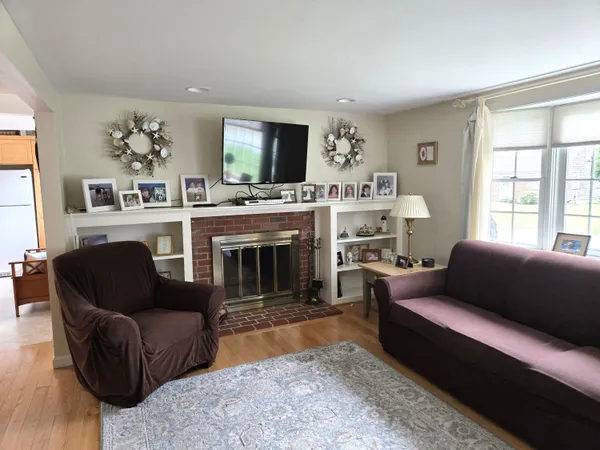 a living room with furniture a flat screen tv and a fireplace