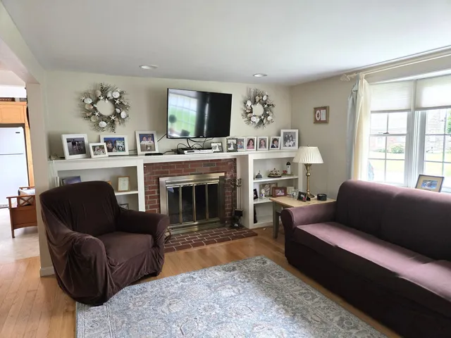 a living room with furniture a flat screen tv and a fireplace