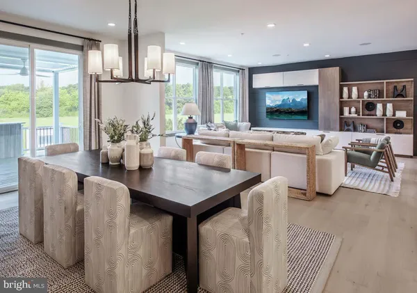 a open kitchen with stainless steel appliances granite countertop a stove a refrigerator a kitchen island a table and chairs