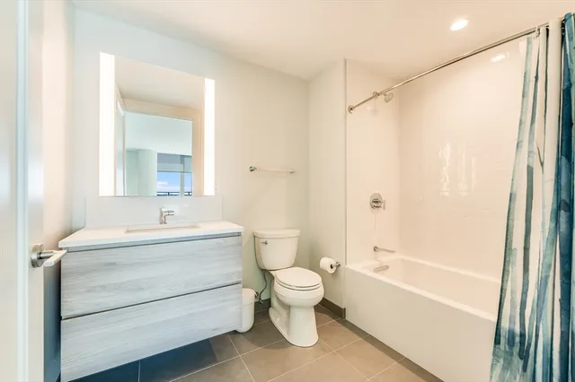 a view of a big room with wooden floor and windows