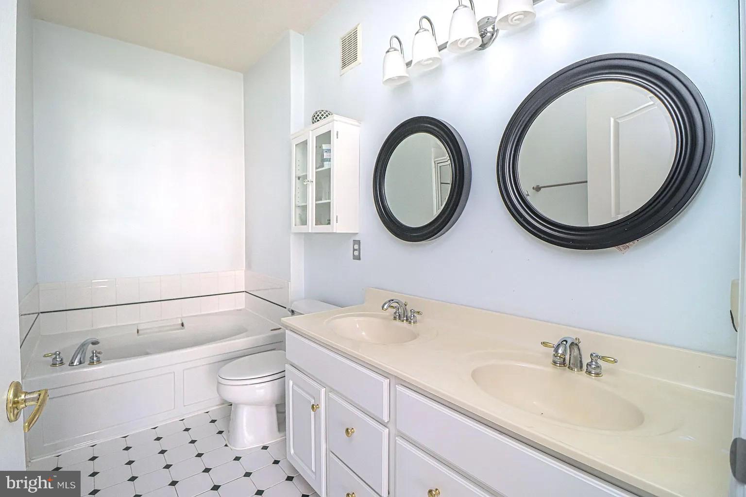 12185 Abington Hall Place, Unit 201 Reston, VA 20190 - Photo 13 of 32 a bathroom with a toilet a sink and a mirror