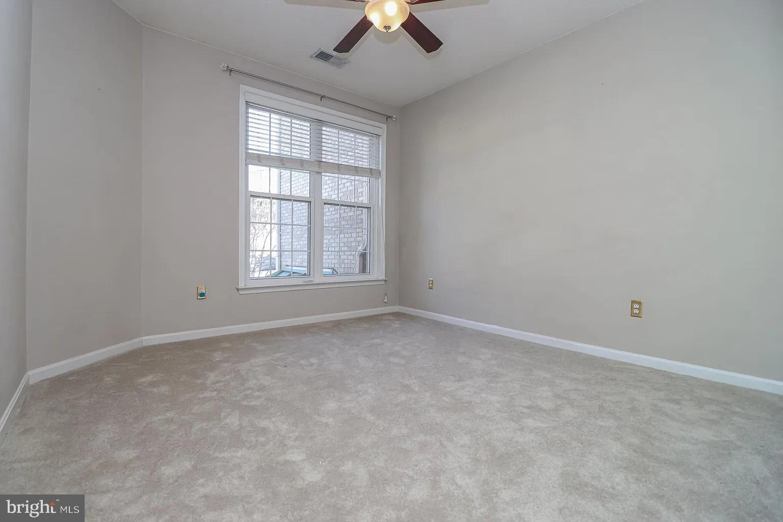 12185 Abington Hall Place, Unit 201 Reston, VA 20190 - Photo 16 of 32 an empty room with a ceiling fan and window