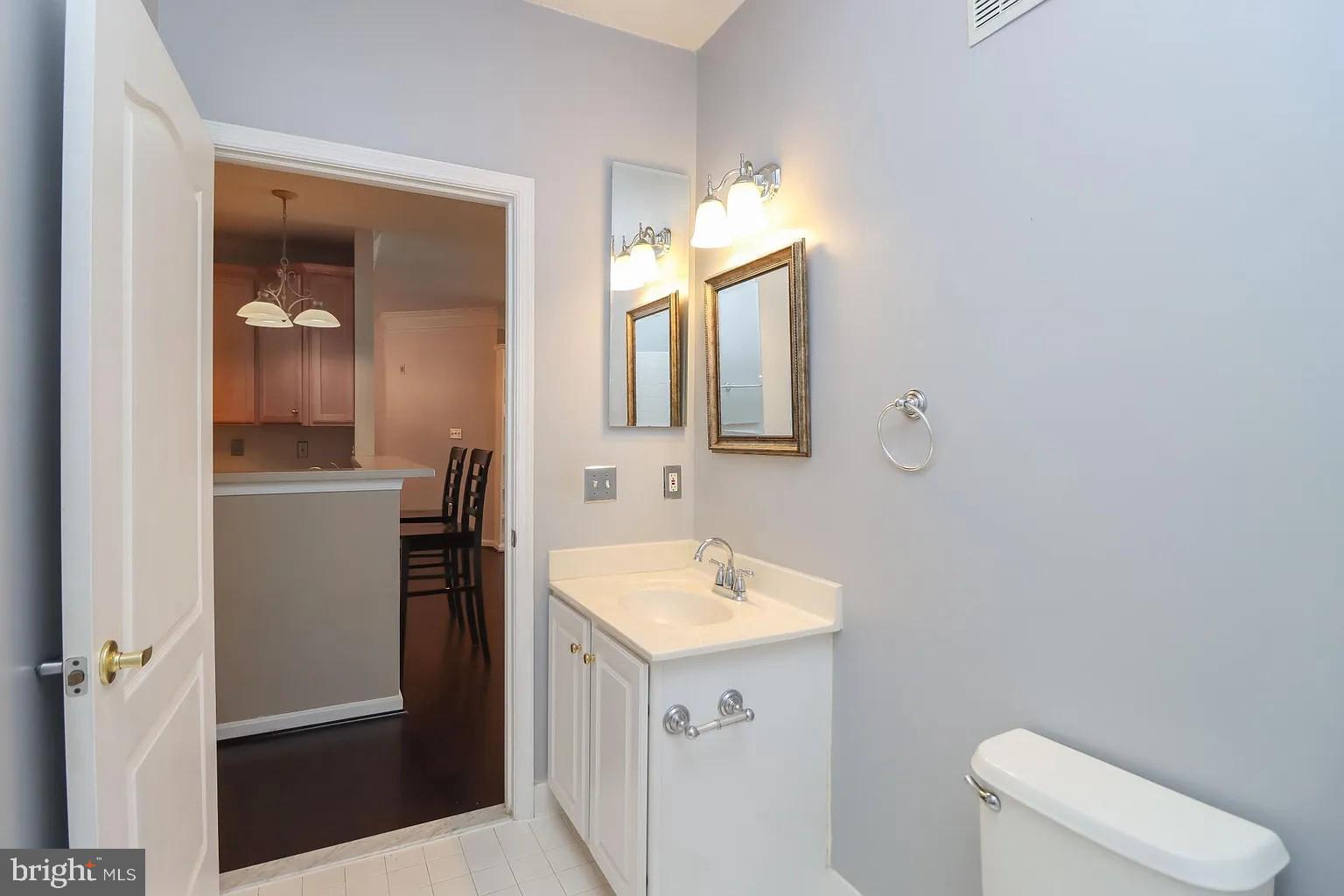 12185 Abington Hall Place, Unit 201 Reston, VA 20190 - Photo 19 of 32 a bathroom with a sink a toilet and mirror