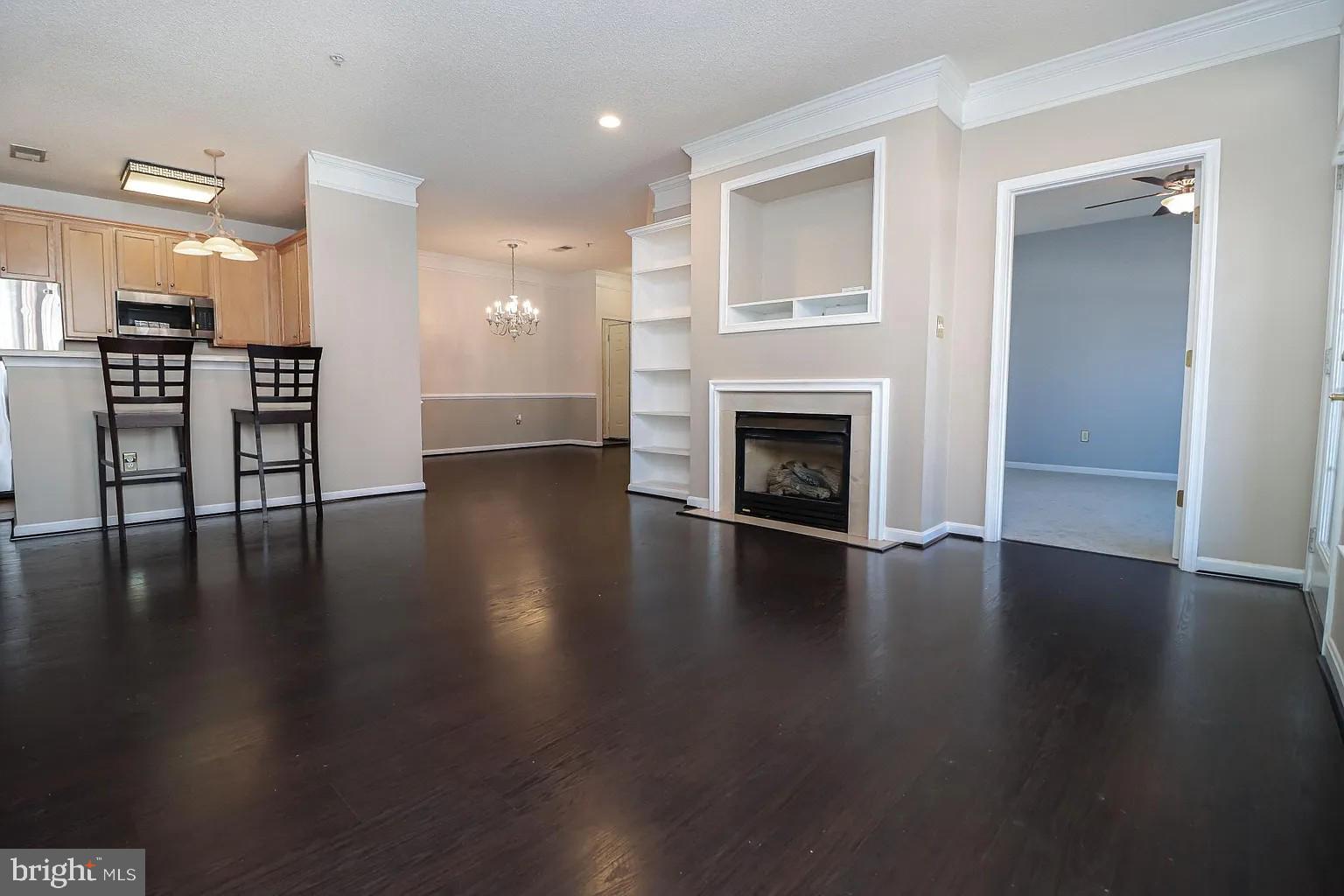 12185 Abington Hall Place, Unit 201 Reston, VA 20190 - Photo 2 of 32 an empty room with wooden floor fireplace and windows