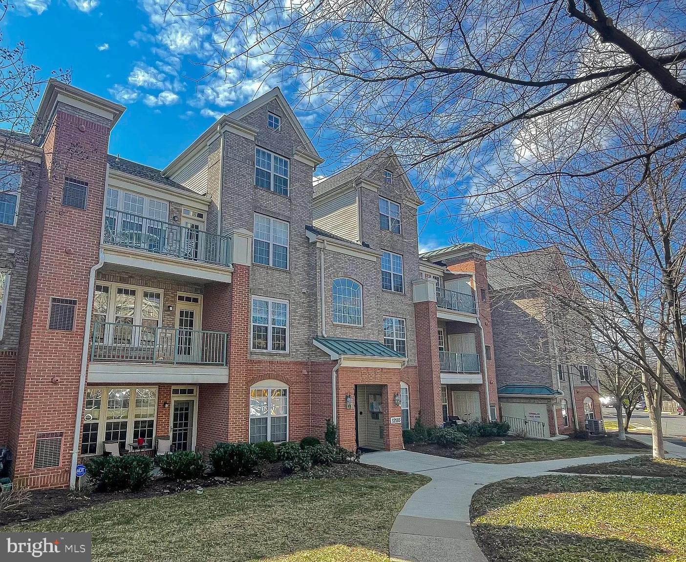 12185 Abington Hall Place, Unit 201 Reston, VA 20190 - Photo 28 of 32 a view of a building next to a yard