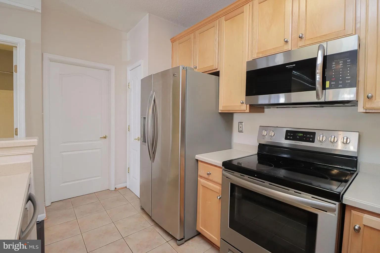 12185 Abington Hall Place, Unit 201 Reston, VA 20190 - Photo 6 of 32 a kitchen with stainless steel appliances a stove microwave and sink