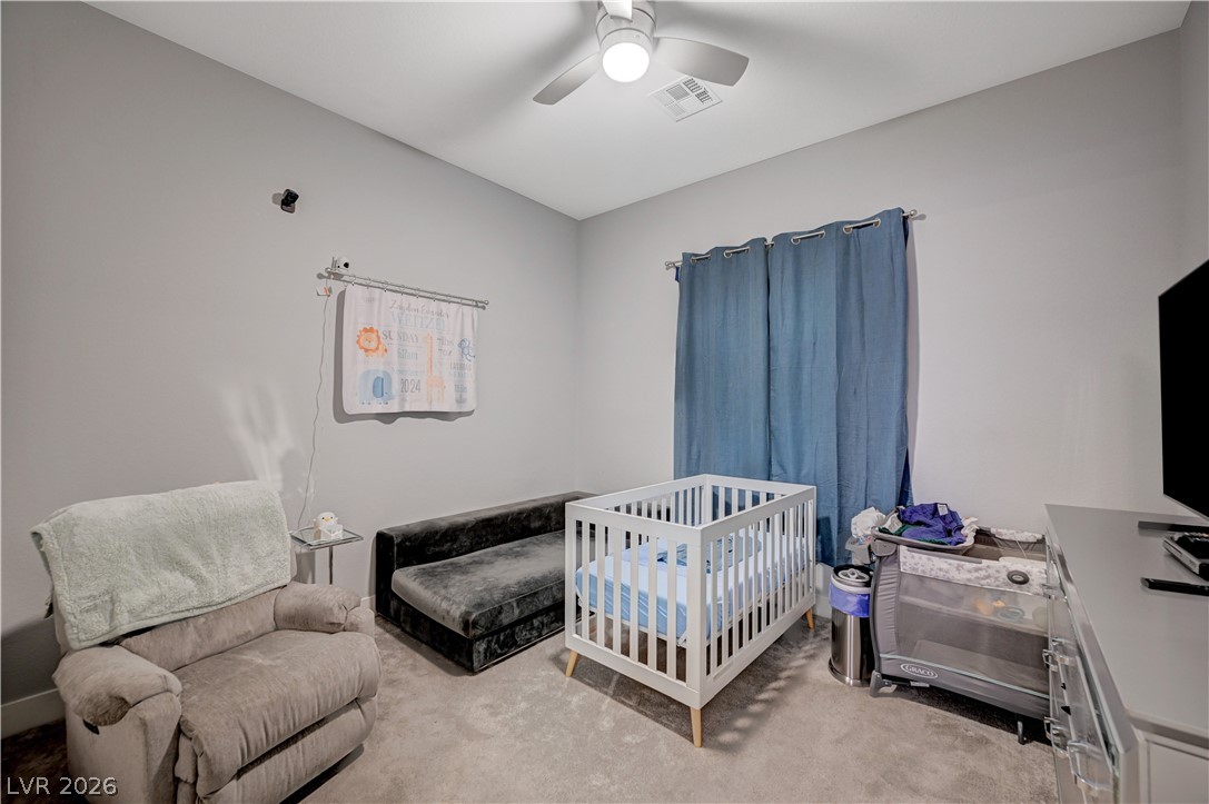 3943 Reyes Avenue Las Vegas, NV 89141 - Photo 24 of 95 A well-lit nursery features soft gray walls and a cozy carpet, ready for peaceful moments.
