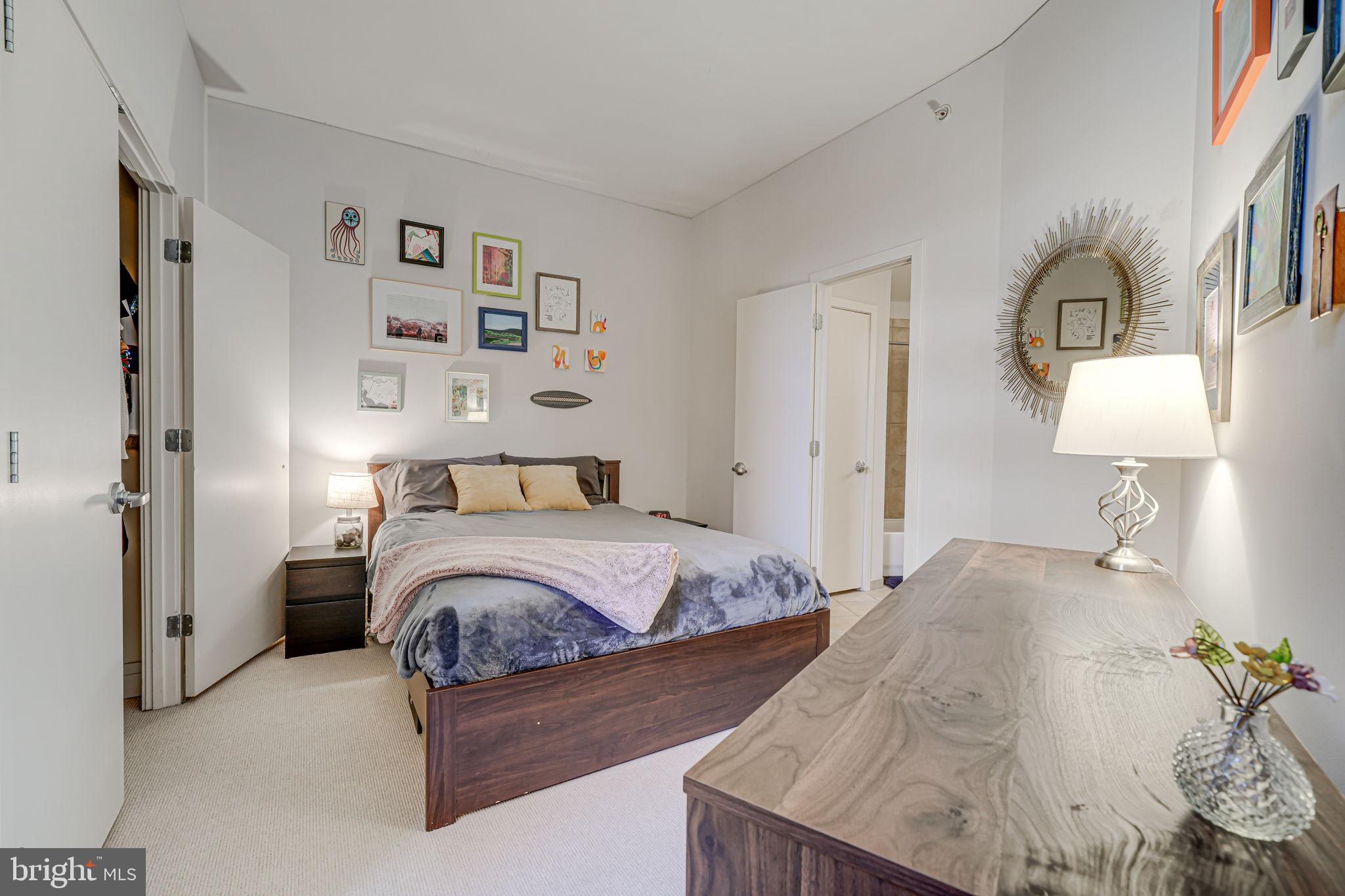 2120 Vermont Avenue Northwest, Unit 16 Washington, DC 20001 - Photo 13 of 21 a bedroom with a bed a mirror and lamp