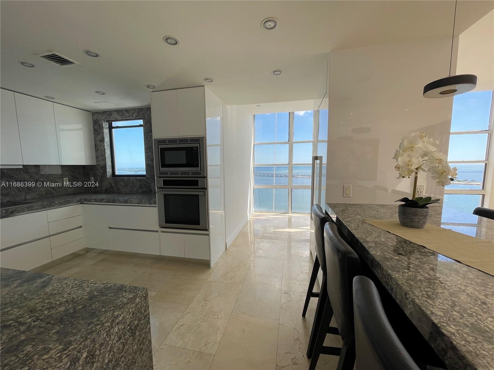1865 Brickell Avenue, Unit APH6 Miami, FL 33129 - Photo 11 of 24 a kitchen with granite countertop a stove and a sink