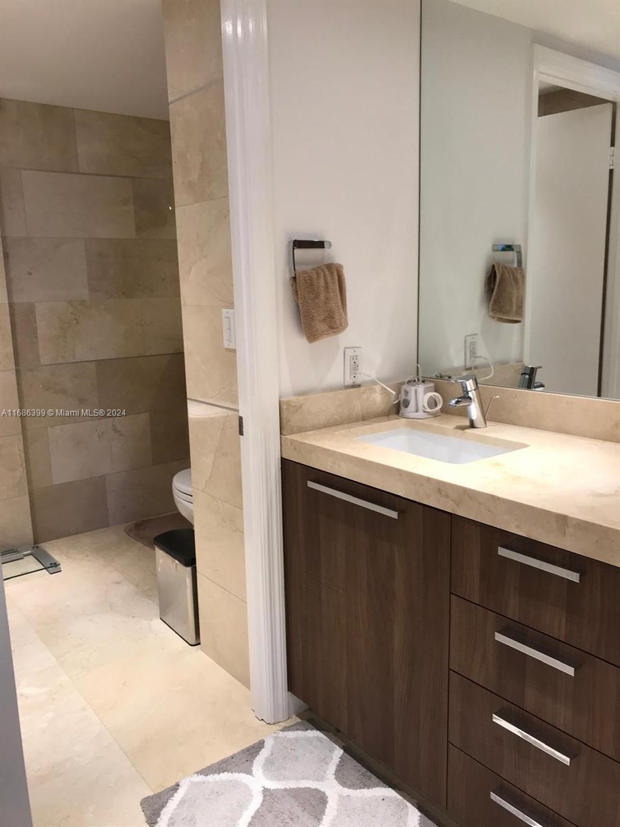 1865 Brickell Avenue, Unit APH6 Miami, FL 33129 - Photo 13 of 24 a bathroom with a sink and a mirror