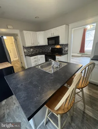 a kitchen with a dining table chairs and granite counter tops