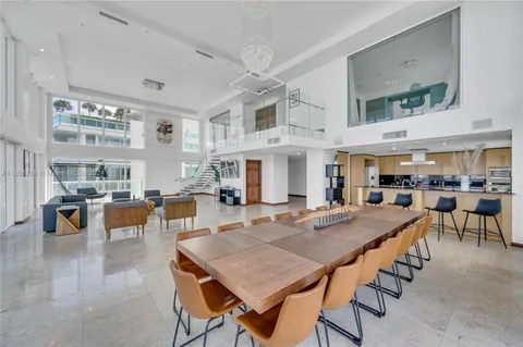 a dining hall with stainless steel appliances granite countertop a table and chairs