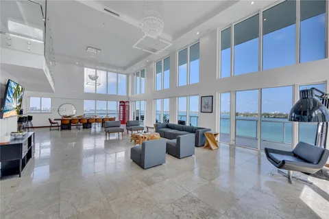 a living room with furniture and a view of kitchen