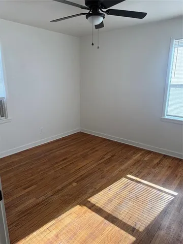 a view of a room with wooden floor and fan