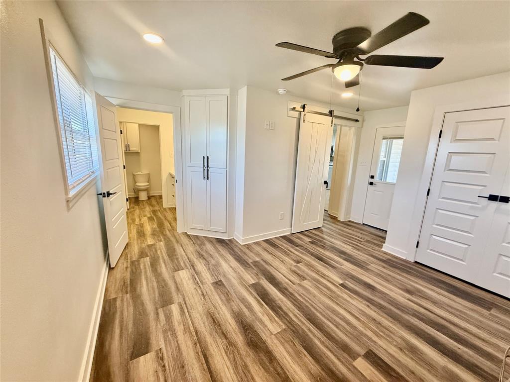 1541 McCarty Aspermont, TX 79502 - Photo 20 of 29 a view of a bedroom with wooden floor and ceiling fan