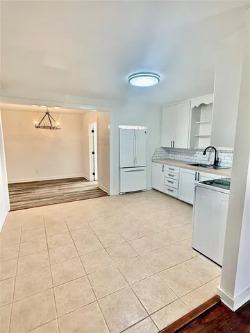 a large white kitchen with cabinets