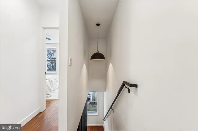 a view of a hallway with wooden floor and staircase