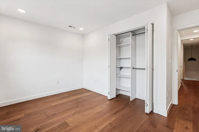 a view of empty room with wooden floor and window