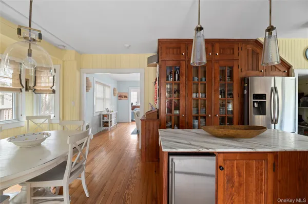 a kitchen with stainless steel appliances granite countertop a sink dishwasher and a refrigerator with wooden floor