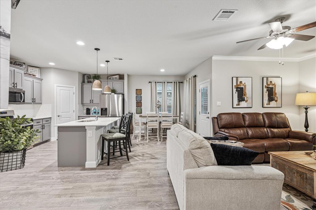 155 Texasage Street Rhome, TX 76078 - Photo 10 of 31 Living room featuring light wood-style flooring, ceiling fan, recessed lighting, and crown molding