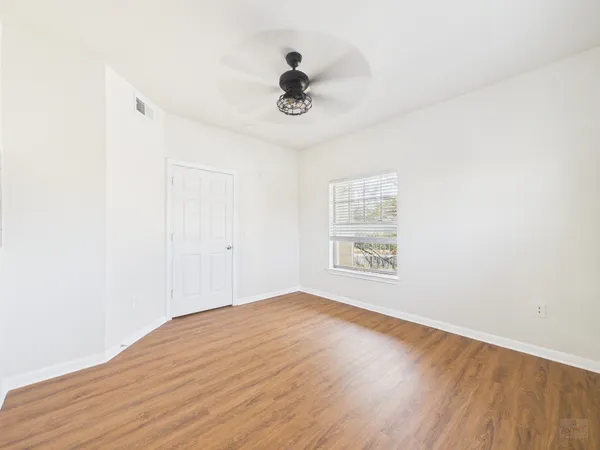 a view of empty room with wooden floor