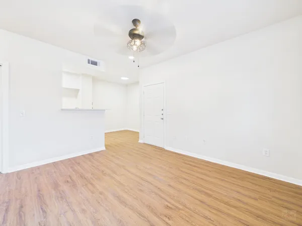 a view of an empty room with wooden floor