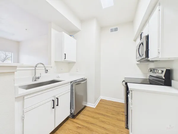 a kitchen with a sink stove and cabinets