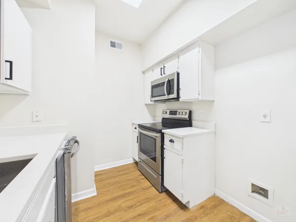 a kitchen with stainless steel appliances a sink cabinets and a stove top oven