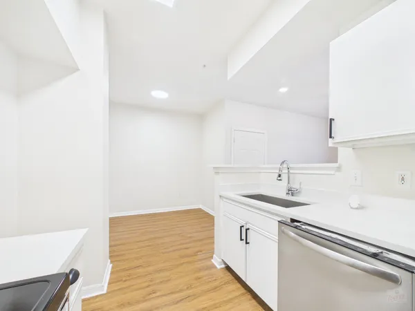 a kitchen with a sink cabinets stainless steel appliances and a window