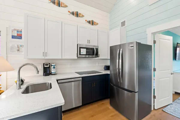 a kitchen with refrigerator a microwave a sink and cabinets