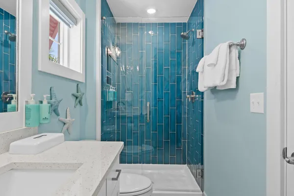 a bathroom with a sink a toilet and shower