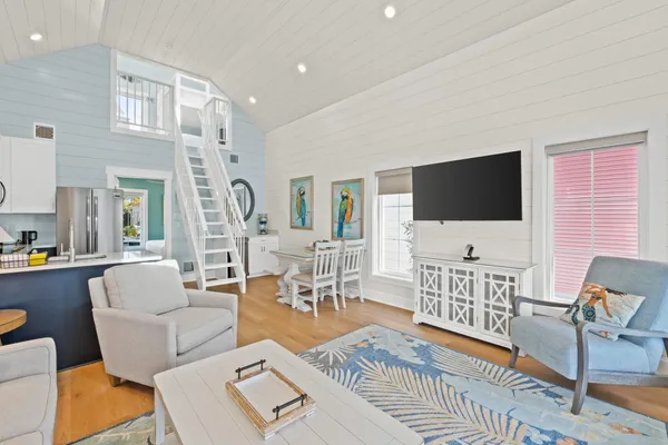 a living room with furniture a flat screen tv a rug and a window
