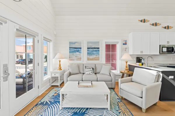 a living room with furniture a flat screen tv and a large window