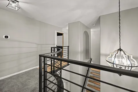 a view of a hallway with wooden floor and staircase